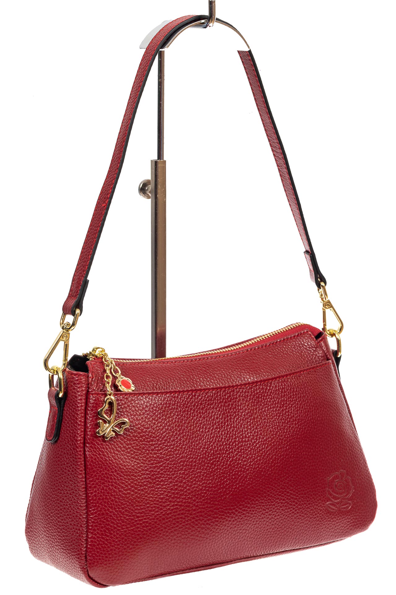 На фото 1 - Небольшая женская сумка из натуральной кожи с металлической подвеской, цвет бордовый