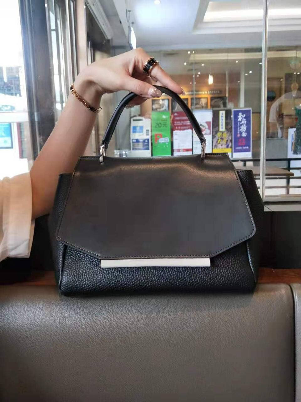 На фото 1 - Женская сумка сэтчел из натуральной кожи с фигурным клапаном, цвет чёрный