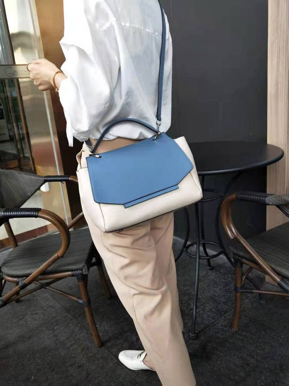 На фото 2 - Женская сумка сэтчел из натуральной кожи с фигурным клапаном, цвет молочный с синим