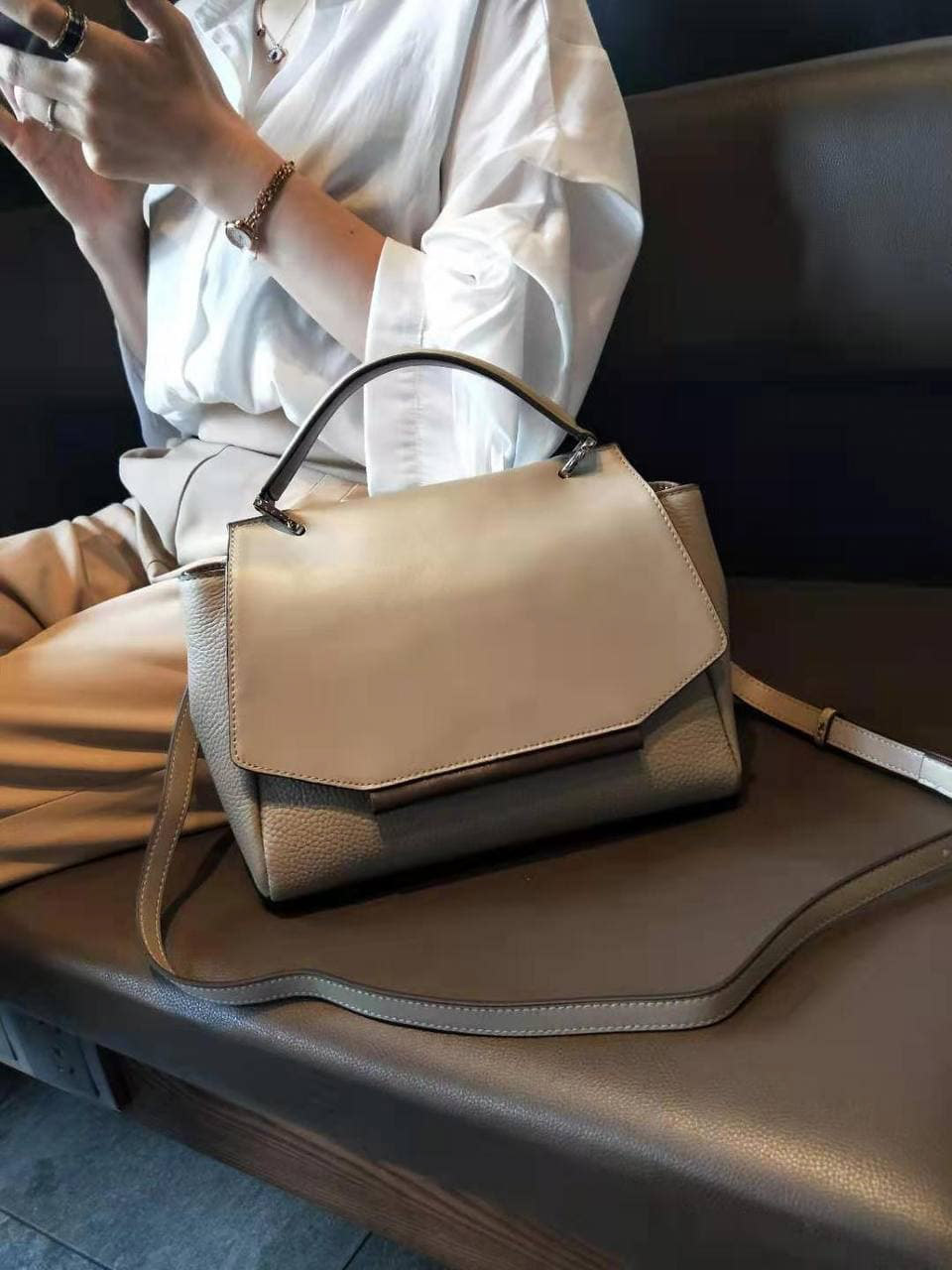 На фото 1 - Женская сумка сэтчел из натуральной кожи с фигурным клапаном, цвет молочный