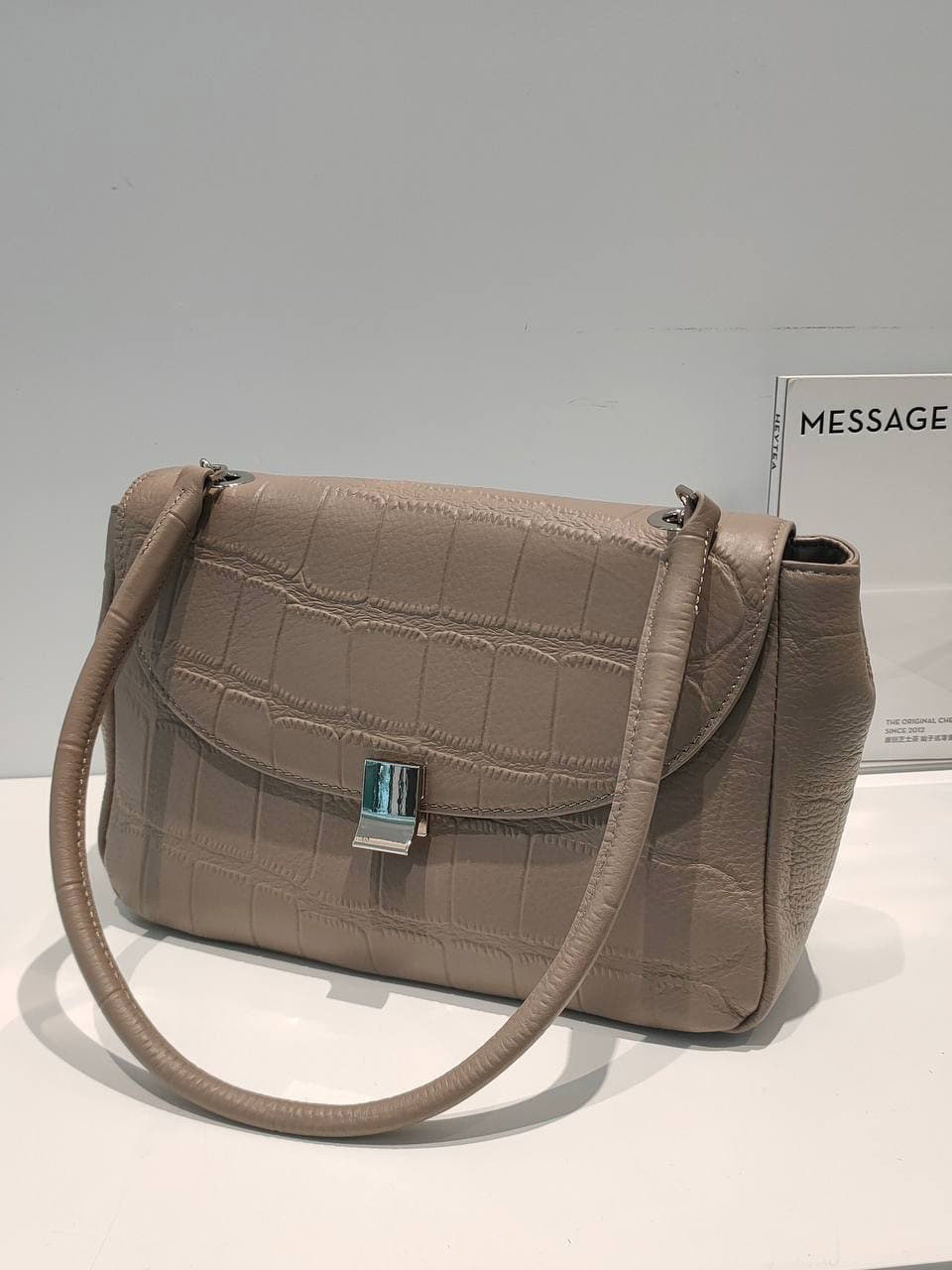 На фото 1 - Женская сумка-трапеция из  из натуральной кожи, цвет бежевый